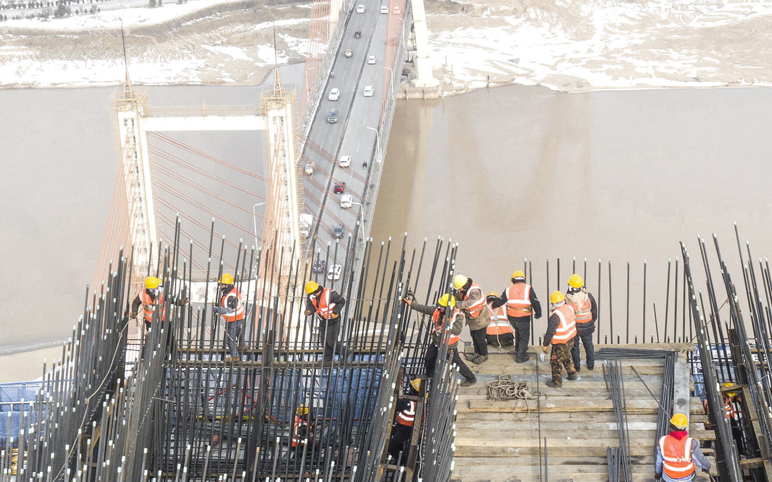 《建设中的黄河大桥》组照  2023年1月16日，大雪过后，工人们不顾寒冷、风大立即复工.jpg