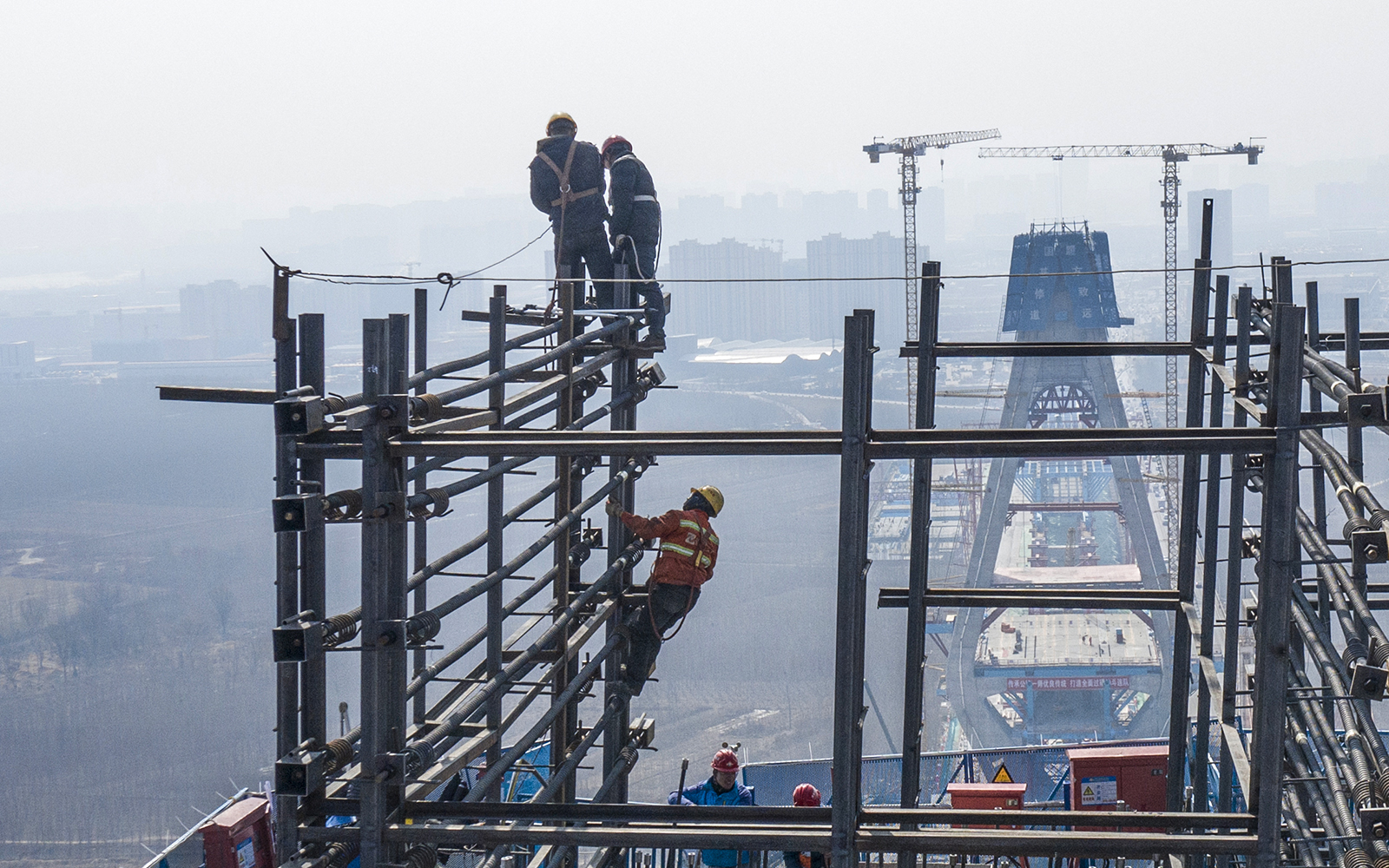 《建设中的黄河大桥》组照  2023年2月26日，大风过后，施工人员校准钢架固件。.jpg