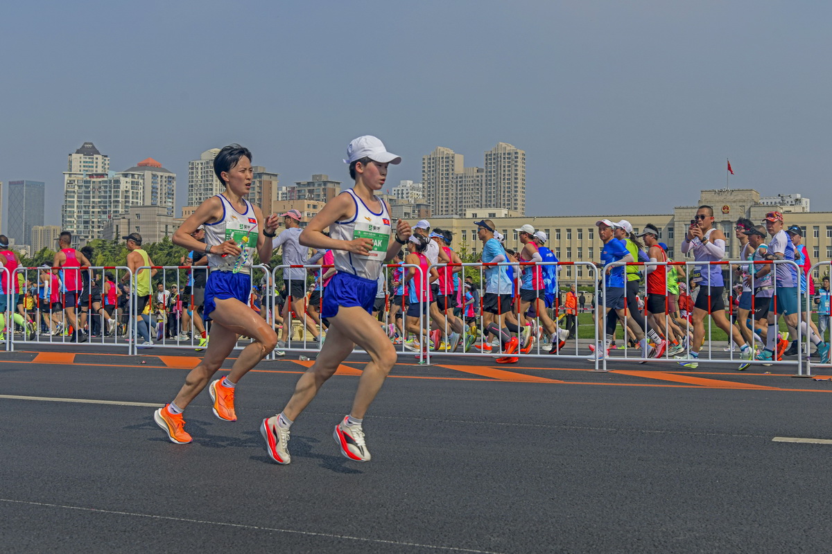 参加大连第36届国际马拉松的两名朝鲜女选手，其中一名腿上粘着胶带选手，紧随其后，形.jpg